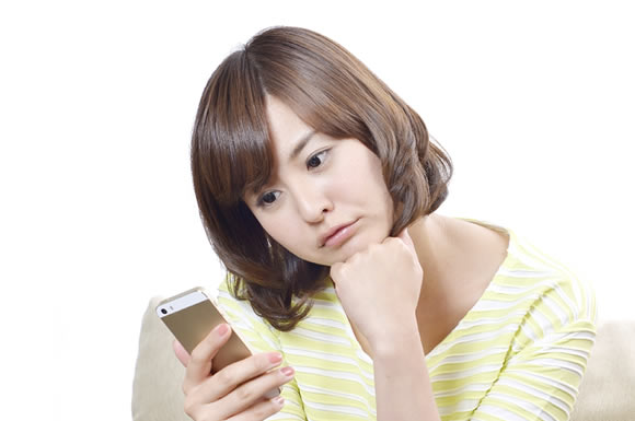 スマートフォンを見ている女性の画像